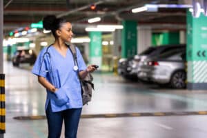 Female nurse looking for a car in the parking lot